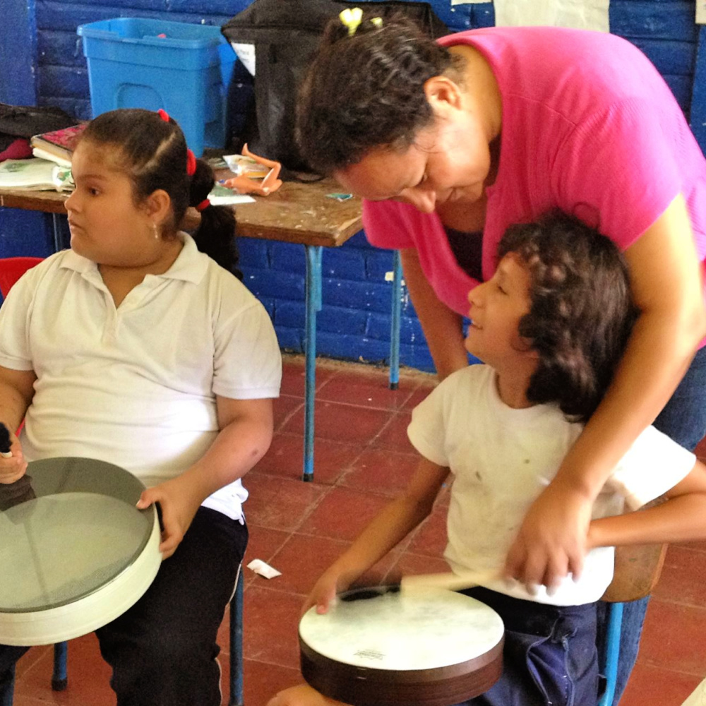Two young children participating in a therapeutic drum experience.